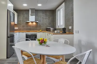 a kitchen with a white table with a bowl of fruit on it at BBarcelona Fira Superior Flats in Barcelona