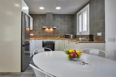 a kitchen with a white table with a bowl of fruit on it at BBarcelona Fira Superior Flats in Barcelona