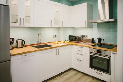 a kitchen with white cabinets and a sink at BBarcelona Fira Superior Flats in Barcelona
