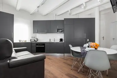 a living room with a table and a couch and a kitchen at Canela Homes BARCELONA MARINA in Barcelona