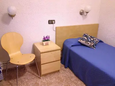 a bedroom with a bed and a chair and a table at Hostal Carlos III in El Prat de Llobregat