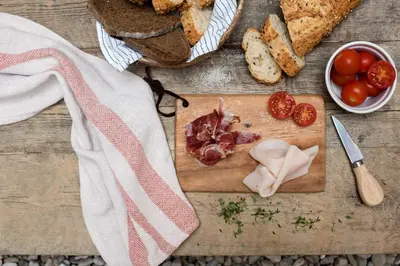 a cutting board with tomatoes and bread and a knife at CASA FILOMENA in Barcelona