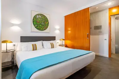 a bedroom with a large bed with a blue blanket at Lodging Apartments City Center-Eixample in Barcelona