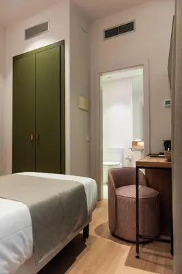 a bedroom with a bed and a desk and a chair at Hotel California in Barcelona