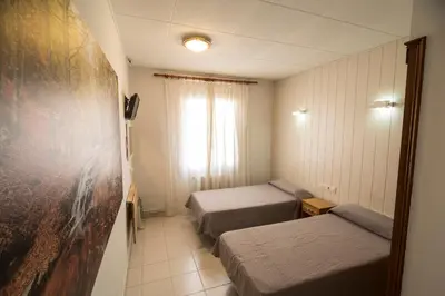 a hotel room with two beds and a window at Turó de L´Home in Santa María de Palautordera