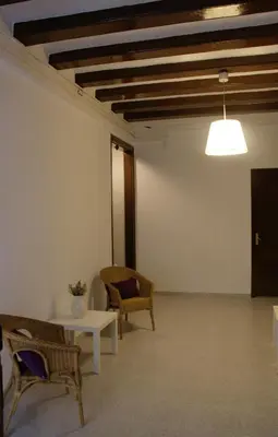a room with chairs and a table and a ceiling at Hostal Dragonflybcn in Barcelona