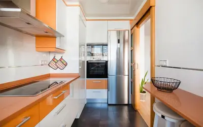 a kitchen with wooden cabinets and a sink at BONITO APARTAMENTO in Sitges