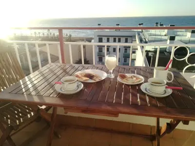 a wooden table with plates of food on a balcony at terraza al mar in Pineda de Mar