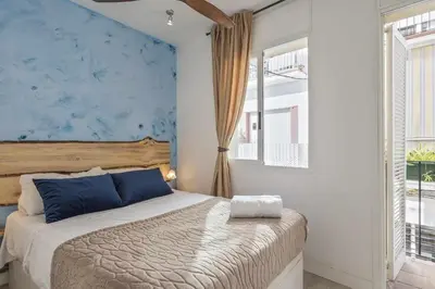 a bedroom with a bed and a blue wall at Apartment Gaudi in Sitges