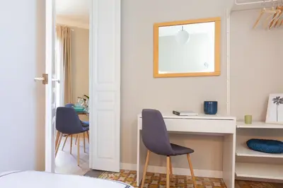a bedroom with a desk and two chairs and a table at My Address on the Beach and Sun in Barcelona