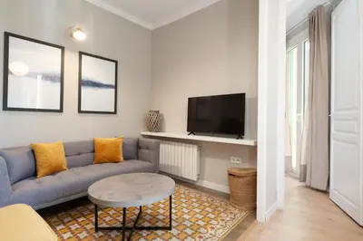 a living room with a blue couch and a tv at My Address on the Beach and Sun in Barcelona