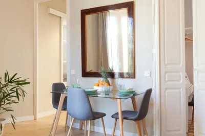 a dining room table with chairs and a mirror at My Address on the Beach and Sun in Barcelona