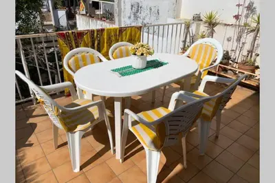 a white table and chairs on a patio at Calella Playa in Calella