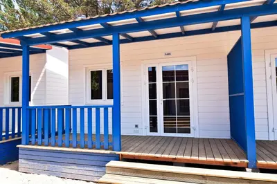 a house with a blue pergola on a deck at Camping La Rueda in Cubelles