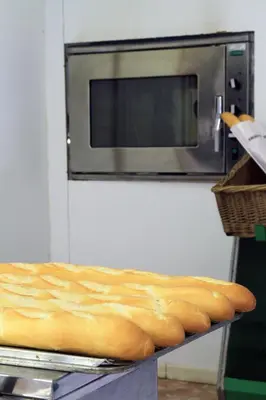 a loaf of bread on a table in front of a microwave at Camping La Rueda in Cubelles