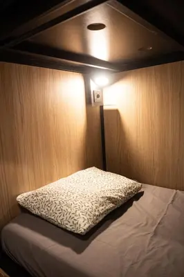 a bed in a small room with a light at Onefam Paralelo in Barcelona