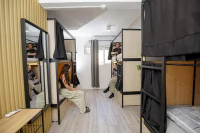 a woman is sitting in a room with mirrors at Onefam Paralelo in Barcelona
