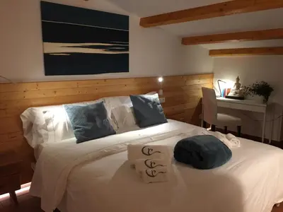 a bedroom with a large white bed and a desk at Villa Can Tomeu Capdet in Sant Pere de Ribes