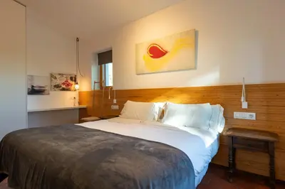 a bedroom with a large bed with a wooden headboard at Villa Can Tomeu Capdet in Sant Pere de Ribes