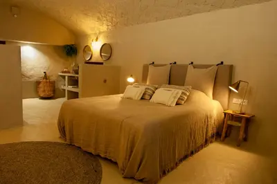 a bedroom with a large bed with white sheets and pillows at Cal Mestre Casa Rural in Avinyonet