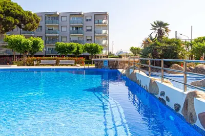 a large swimming pool in front of a building at Residencial Costamar next Bcn, 50m beach with swimming pool in Cabrera de Mar