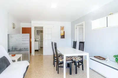 a kitchen and living room with a table and chairs at Residencial Costamar next Bcn, 50m beach with swimming pool in Cabrera de Mar