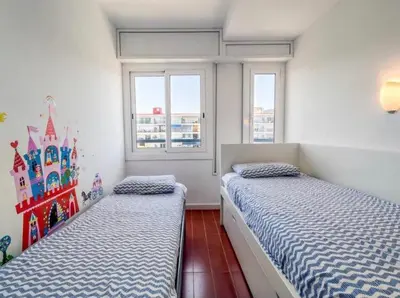 two beds in a bedroom with a castle mural on the wall at Can Mabi, 30' Bcn next beach in Vilassar de Mar