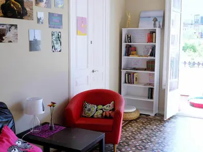 a living room with a red chair and a table at Fabrizzio's Petit in Barcelona