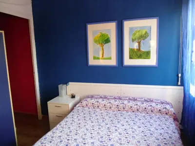 a blue bedroom with a bed and two pictures on the wall at Atico Soleado Vistas panoramicas in Hospitalet de Llobregat