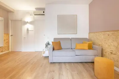 a living room with a gray couch and yellow pillows at Chic and Modern Apartments in Gracia in Barcelona