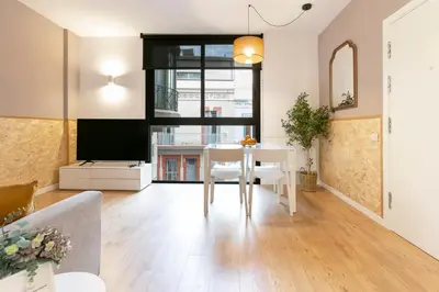 a living room with a table and a television at Chic and Modern Apartments in Gracia in Barcelona