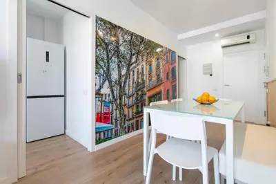 a dining room with a white table and a painting on the wall at Chic and Modern Apartments in Gracia in Barcelona