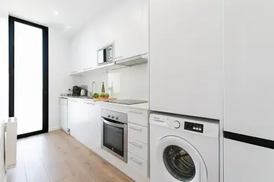 a kitchen with a sink and a counter with oranges at Chic and Modern Apartments in Gracia in Barcelona