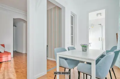 a dining room with a white table and blue chairs at Alcam Berlin-Numancia in Barcelona