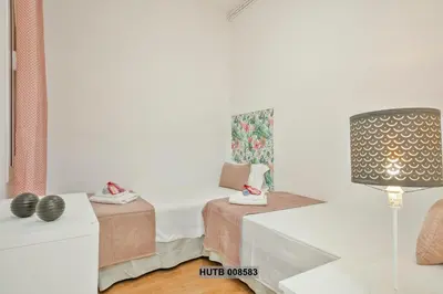 a bedroom with a bed and a table with a lamp at Alcam Berlin-Numancia in Barcelona