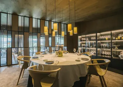 a dining room with a white table and chairs at Les Cabanes de l'Oller del Mas in Manresa