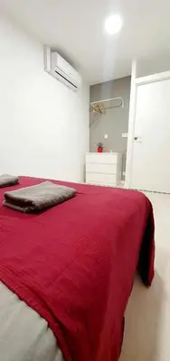 a bedroom with a red blanket on a bed at Hostal Urban Basic in Hospitalet de Llobregat