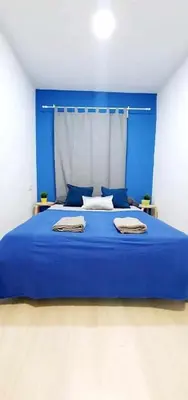 a blue bed with two towels on it in a room at Hostal Urban Basic in Hospitalet de Llobregat