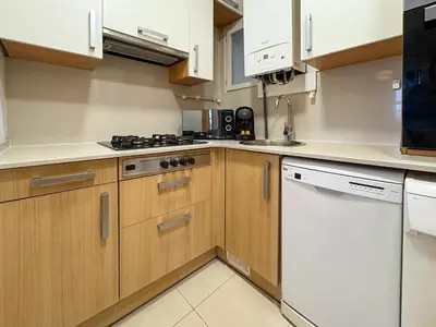 a kitchen with wooden cabinets and a white dishwasher at Stay U-nique Apartments Borbó in Barcelona