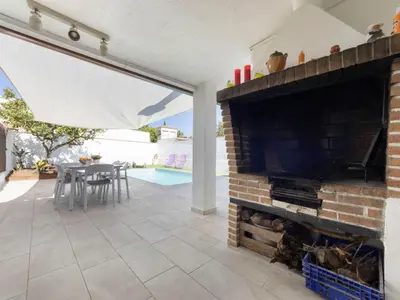 a living room with a fireplace and a table with chairs at Holiday Home Aeris by Interhome in Cunit