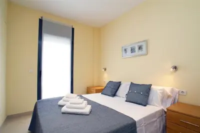 a bedroom with a bed with towels on it at Apartamentos Sitges in Sitges