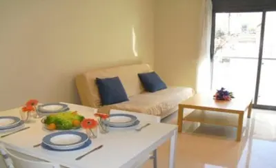 a living room with a table and a couch at Apartamentos Sitges in Sitges
