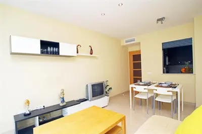 a living room with a table and a dining room at Apartamentos Sitges in Sitges