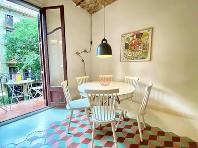 a dining room with a table and chairs and a window at Tyche apartment in Barcelona