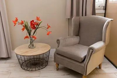 a chair and a table with a vase with flowers at Cami Gallery Barcelona in Barcelona