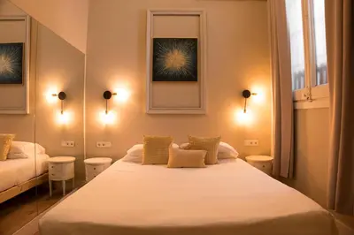a bedroom with two beds and two windows at Cami Gallery Barcelona in Barcelona