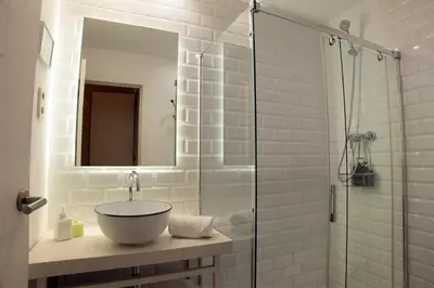 a bathroom with a sink and a glass shower at Cami Gallery Barcelona in Barcelona