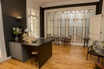 a living room with a table and chairs and a large window at Cami Gallery Barcelona in Barcelona