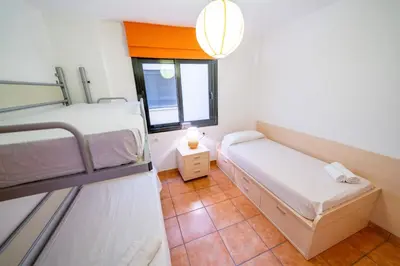 a room with two bunk beds and a window at HomeHolidaysRentals Adara in Pineda de Mar