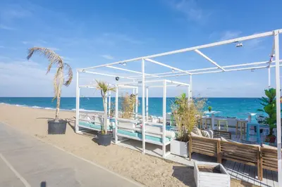 a pavilion on the beach next to the ocean at HomeHolidaysRentals Marella - Costa Barcelona in Pineda de Mar